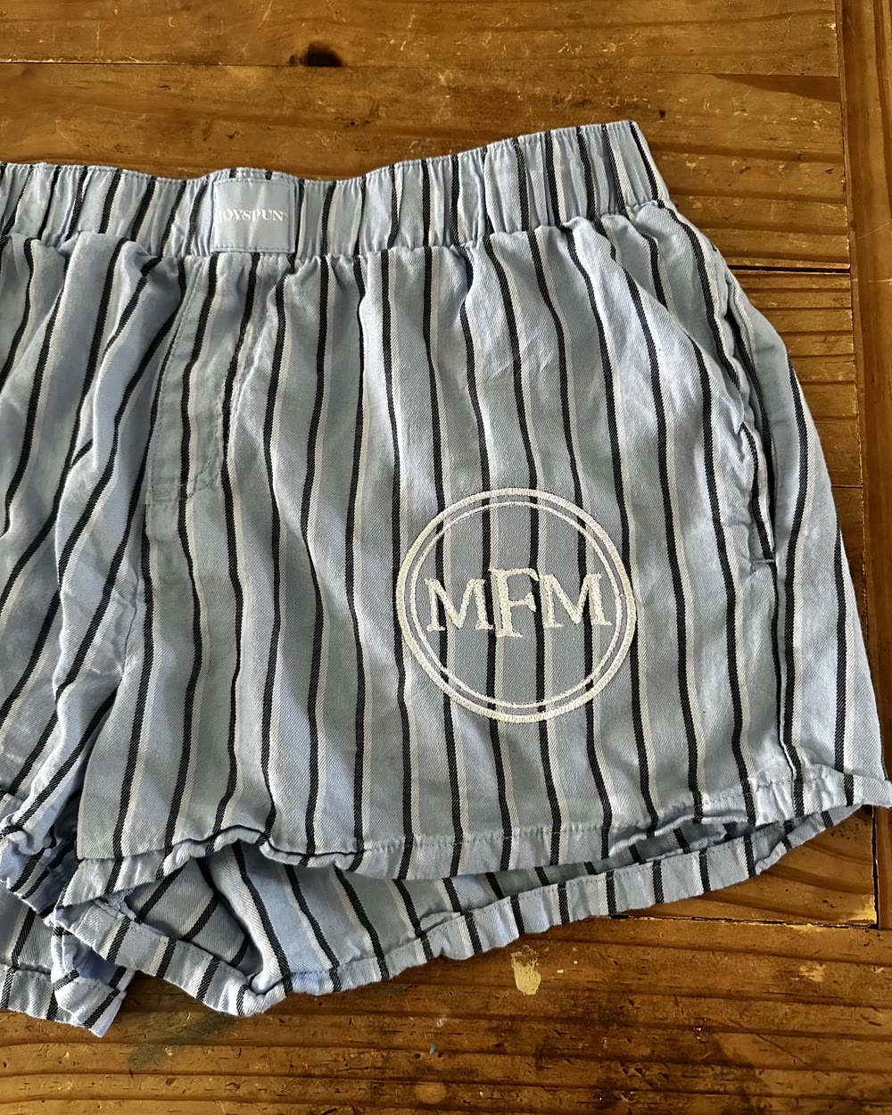 Grey striped shorts embroidered with a circular MFM monogram