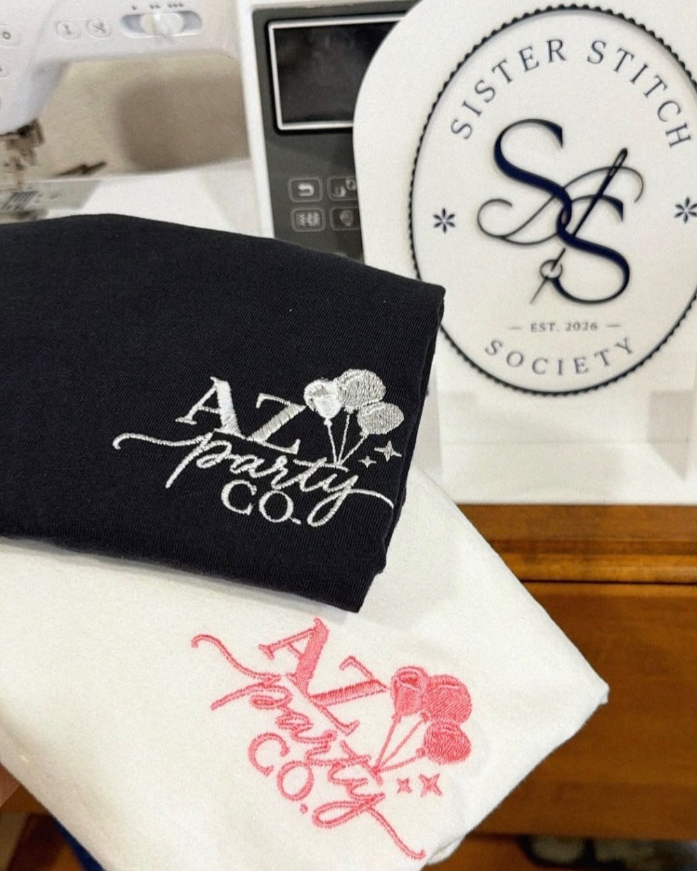 A navy sweatshirt and a cream tee, both embroidered with the AZ Party Co logo
