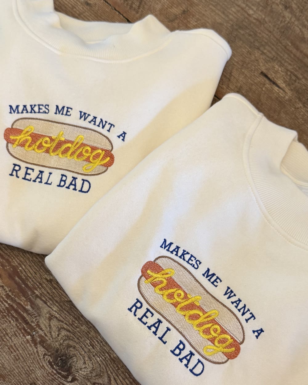 Two cream sweatshirts embroidered Makes me want a hotdog real bad